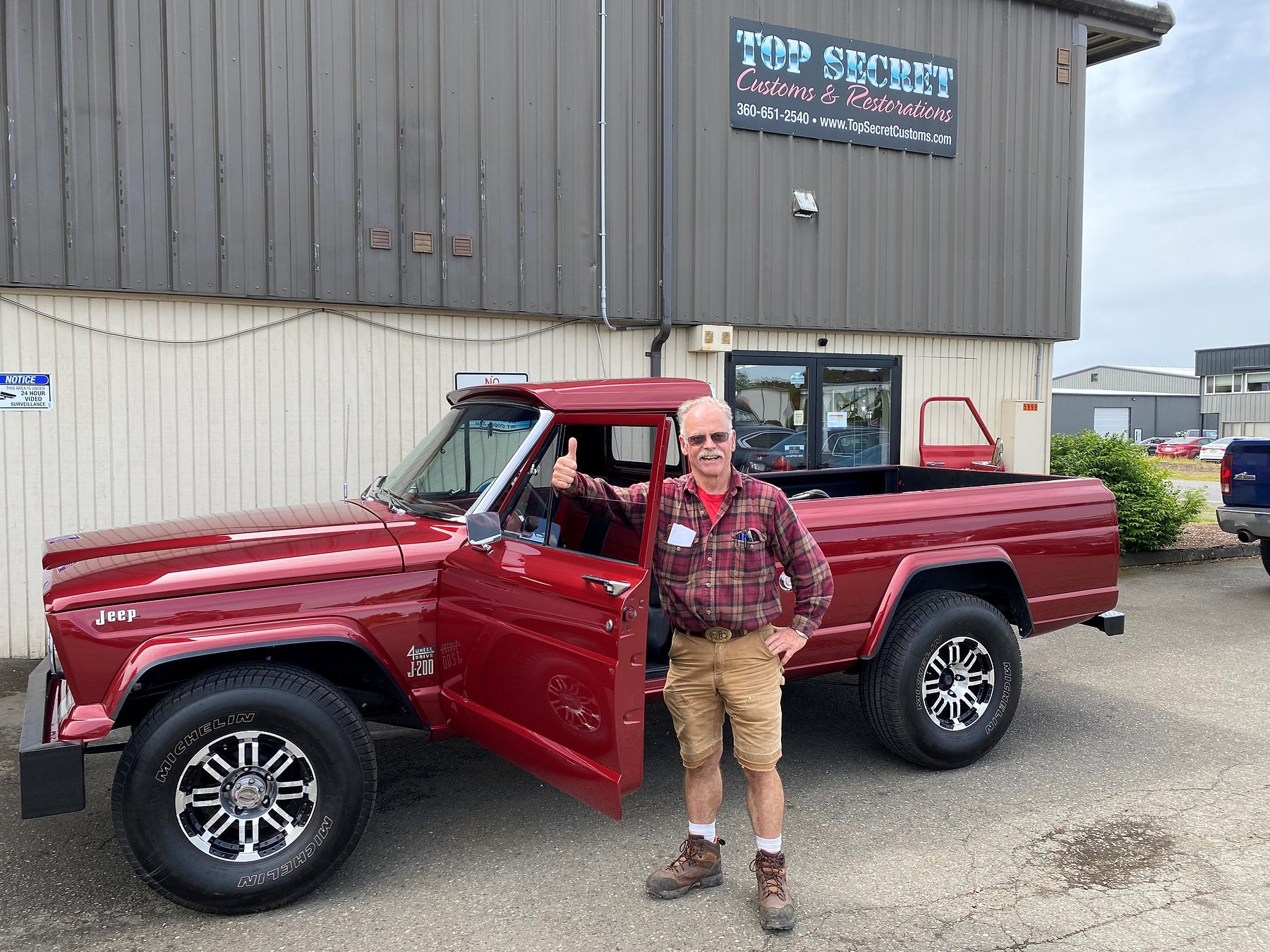 Completed red 1963 Jeep Gladiator outside Top Secret Customs